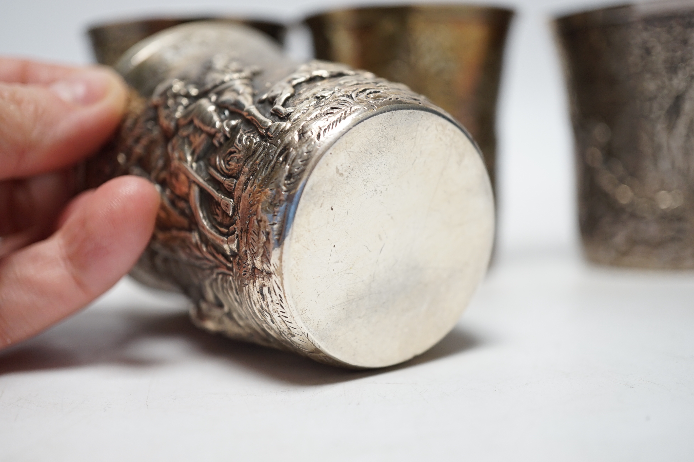 A set of five late 19th century German embossed 925 beakers, decorated with continuous hunting scenes, by Neresheimer Ludwig & Co, 67mm, 16.7oz